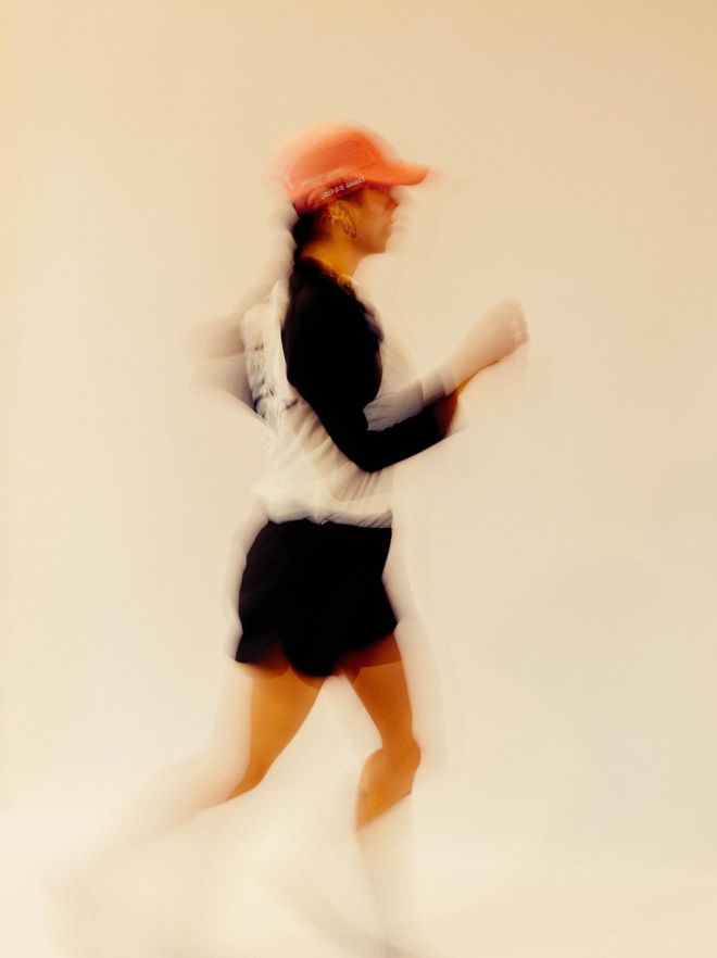 Mujer corriendo con gorra rosa salmón de secado rápido.